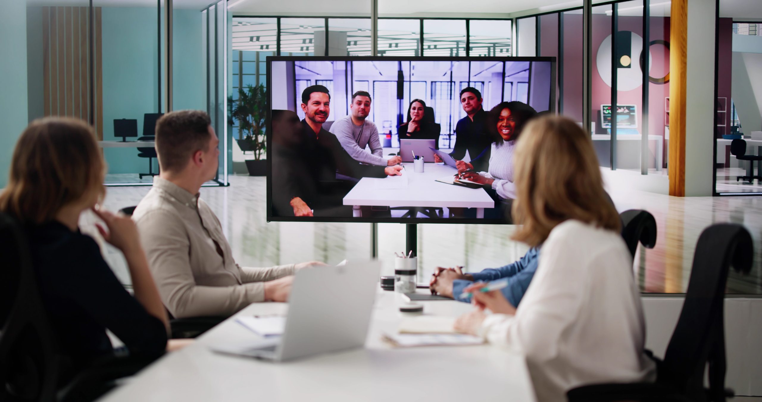 Group,Of,Businesspeople,Having,Video,Conference,With,Another,Business,Team